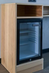 a tv in a wooden cabinet with a glass door at Black Sea Resort in Primorskoye