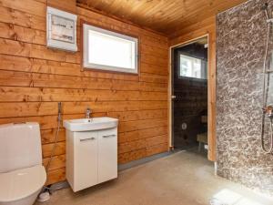 a bathroom with a toilet and a sink and a window at Holiday Home Kaislajärven huvila by Interhome in Risulahti