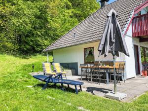 eine Terrasse mit Sonnenschirm und Tisch und Stühlen in der Unterkunft Holiday Home LoLa by Interhome in Kirchheim