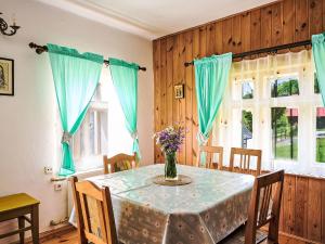a dining room table with a vase of flowers on it at Holiday Home U Myšáka by Interhome in Tanvald +27 photos