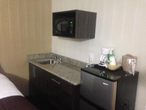 a kitchen with a sink and a microwave at Days Inn by Wyndham Sylvan Lake in Sylvan Lake