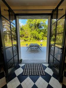 an open door to a patio with a table and chairs at La Casita in Mimizan