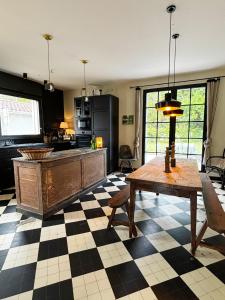 a kitchen with a checkered floor and a wooden table at La Casita in Mimizan
