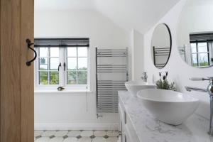 a white bathroom with two sinks and a mirror at 4-Bed Cottage in the Lizard - Pet Friendly in Helston +21 photos
