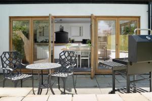 a patio with a grill and a table and chairs at 4-Bed Cottage in the Lizard - Pet Friendly in Helston