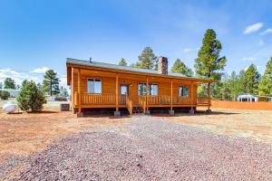 a log home with a large porch and a yard at Near Hiking Trails Overgaard Home with Large Yard! in Overgaard