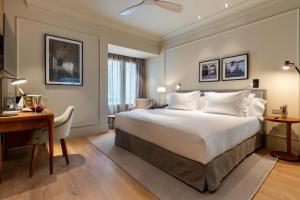 科爾多瓦的住宿－H10 Palacio Colomera，酒店客房配有一张床、一张书桌和一张书桌。