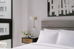 a bedroom with a white bed and a nightstand with a bed sidx sidx sidx at Sonder Court Square in Long Island City