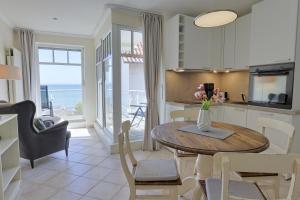 a kitchen and dining room with a table with flowers on it at Strandhaus Brunhild in Timmendorfer Strand