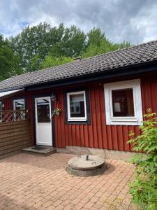 ein rotes Haus mit einer weißen Tür und einer Terrasse in der Unterkunft Bart’s loft in Älmhult + 3 Fotos