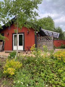 a red house with a white window and a fence at Bart’s loft in Älmhult