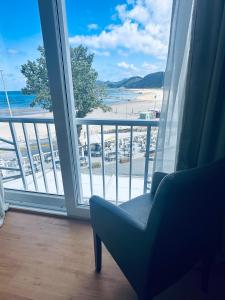 a chair in a room with a view of a beach at Hotel Las Olas in Noja