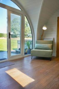 a living room with a couch and a large window at EASTRIDGE GLAMPING in Shrewsbury