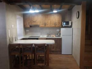 a kitchen with wooden cabinets and a white refrigerator at La Calzada del Canto in Melarde