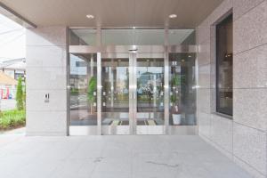un accès à un bâtiment avec des portes en verre dans l'établissement Hotel Route-Inn Saiki Ekimae, à Saiki