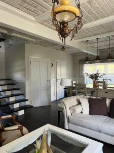 ein Wohnzimmer mit einer Couch und einem Kronleuchter in der Unterkunft Bay Cottage wynajem domków in Swarzewo