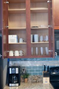 a kitchen cabinet with cups and dishes in it at Uptown CLT - Modern Townhouse in Charlotte