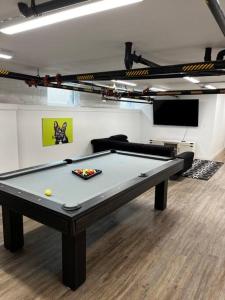 una mesa de billar en una habitación con sofá y mesa en Columbus Gem with Pool Table! Pets Welcome!, en Columbus