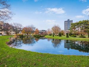 un estanque en un parque con una ciudad al fondo en Columbus Gem with Pool Table! Pets Welcome!, en Columbus
