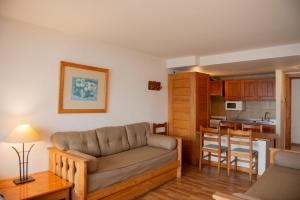 a living room with a couch and a kitchen at Apart Del Lago in San Carlos de Bariloche