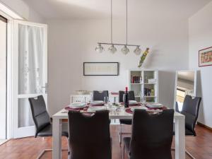 a dining room with a white table and black chairs at Holiday Home Incantevole by Interhome in Soiano del Lago