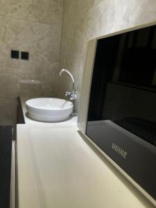 a television on a counter in a bathroom with a sink at اجنحه ايلاف للشقق المخدومة المطوره in Abha +4 photos
