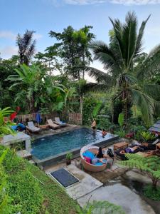 a pool with people laying in a tub in a resort at Tetebatu Sama Sama Bungalows in Tetebatu