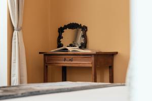 a dressing table with a mirror and a book on it at NAMAN HOTELLERIE - Monti in Rome