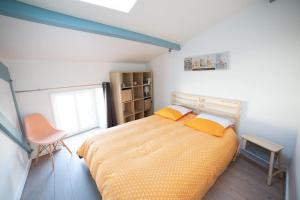 a bedroom with a bed with two yellow pillows at Maison type Loft - avec parking en plein centre in La Rochelle