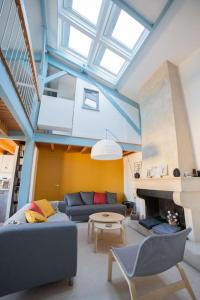 a living room with a couch and a fireplace at Maison type Loft - avec parking en plein centre in La Rochelle