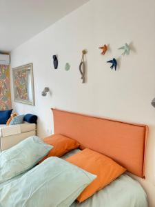 a bed with an orange headboard and birds on the wall at The home Privacy in Marseille