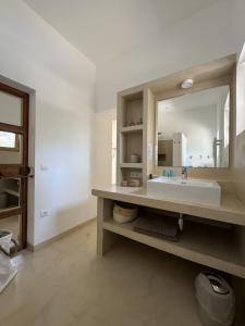 un bagno con lavandino e specchio di Feliz Lagartija a Cala Saona