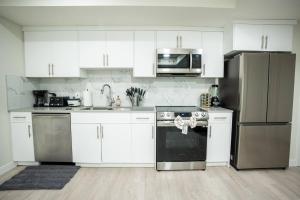 a kitchen with white cabinets and stainless steel appliances at Warm getaway Perfect for 4 in Edmonton