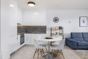 Una cocina y una sala de estar con una mesa y un sofá azul. en Relax Trogir, en Trogir