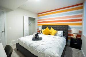 a bedroom with a bed with a colorful striped wall at Warm getaway Perfect for 4 in Edmonton