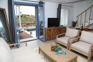 a living room with two chairs and a television at White Dream Suites Antiparos in Antiparos