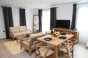 a living room with a table and chairs and a television at White Dream Suites Antiparos in Antiparos