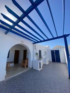 un gran edificio blanco con techo azul en Hôtel Djerba Authentique - Au centre de Midoun en Midoun