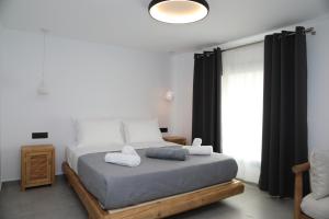 a bedroom with a bed with two towels on it at White Dream Suites Antiparos in Antiparos