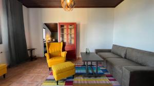 a living room with a couch and a table and yellow chairs at Villa Concordia in Budva