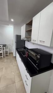 a kitchen with white cabinets and a black counter top at Serene Selena Bay Apartments in Hurghada