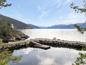 a dock on a lake with mountains in the background at Holiday Home Veganeset II by Interhome in Balestrand