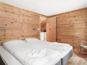 a large white bed in a room with wooden walls at Holiday Home Veganeset II by Interhome in Balestrand