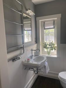 ein Bad mit einem Waschbecken, einem Fenster und einem WC in der Unterkunft Bay Cottage wynajem domków in Swarzewo + 61 Fotos