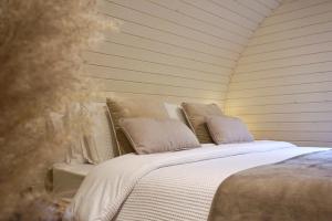 uma cama branca com almofadas em cima em EASTRIDGE GLAMPING em Shrewsbury