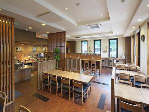 une salle à manger avec des tables et des chaises en bois dans l'établissement Hotel Route-inn Yaita, à Yaita