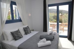 a bedroom with a large bed with a large window at White Dream Suites Antiparos in Antiparos +37 photos