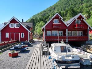 a boat is docked in front of two red buildings at Holiday Home Krokeggi by Interhome in Arnefjord