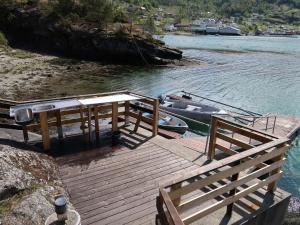 a wooden dock with a boat on the water at Holiday Home Blå Hytte by Interhome in Herand