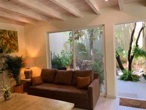 a living room with a couch and a large window at Perfect get away walking distance to centro in San Miguel de Allende
